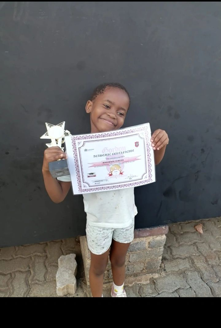 Mogowane Nomusa holding her Gordon Academic Certificate and star trophy